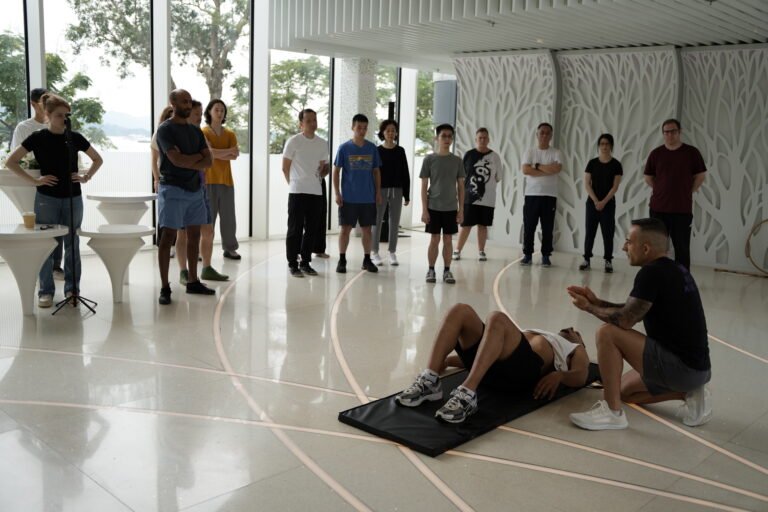 September Camp, Mindful Wing Chun. Students looking at Sifu Nima demonstrating using Student on the floor infront of him.